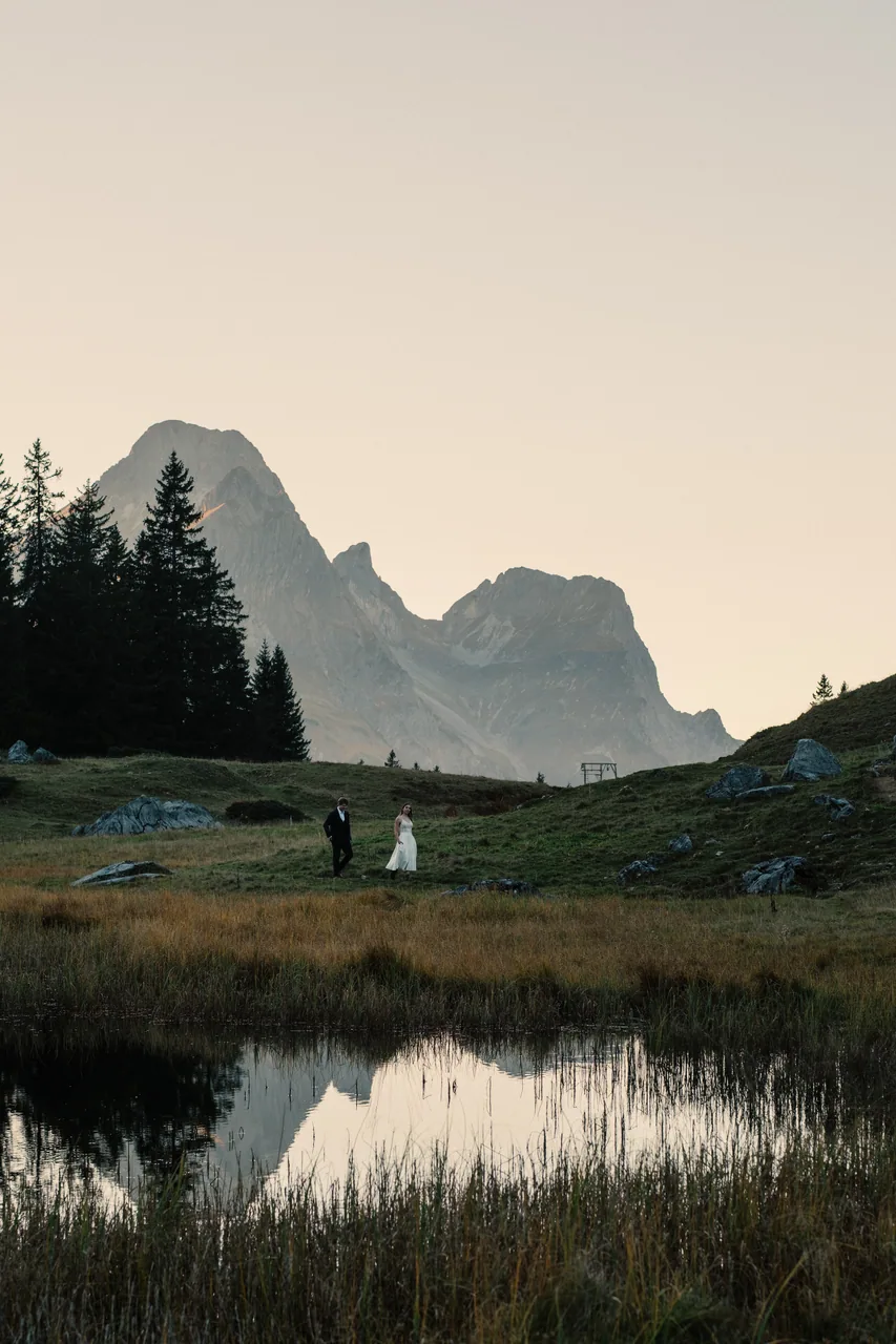 Bride and groom beside a still mountain lake in the Austrian Alps on their elopement day