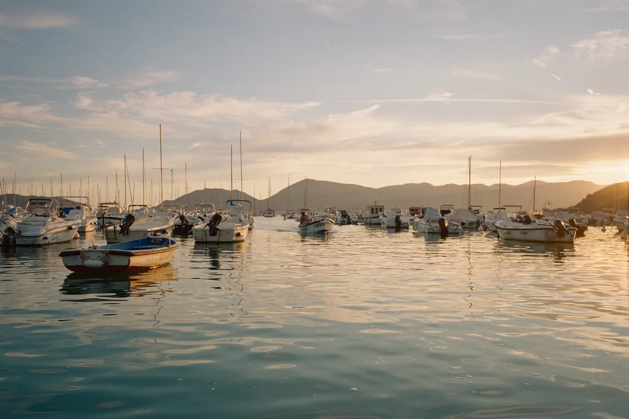 A coastal harbour at golden hour, shot on colour negative film