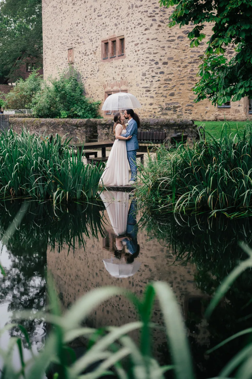 Wedding couple in front of an old stone castle in Germany