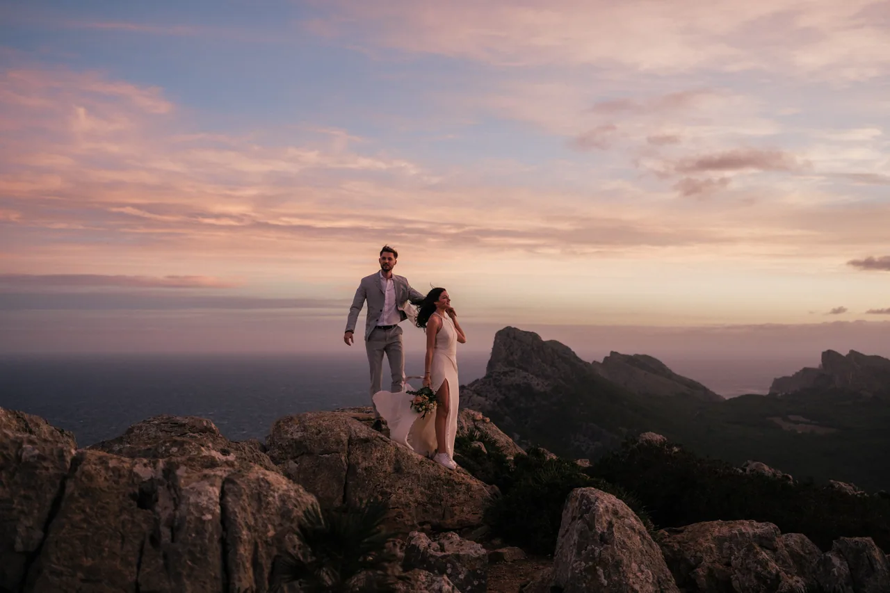 Ein Paar auf einem felsigen Grat der Tramuntana im Sonnenuntergang auf Mallorca
