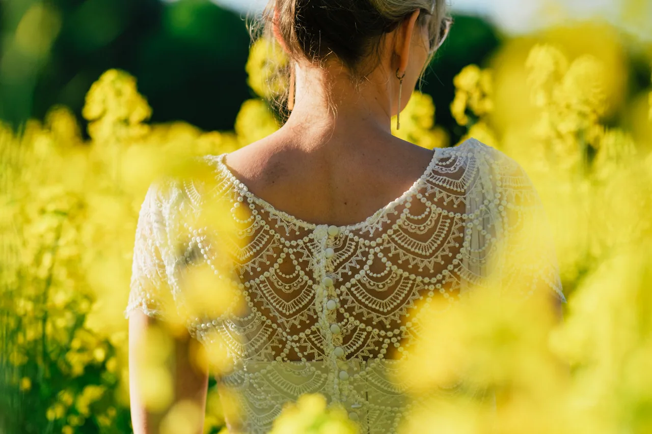 Lace details of a bride in a rapeseed field