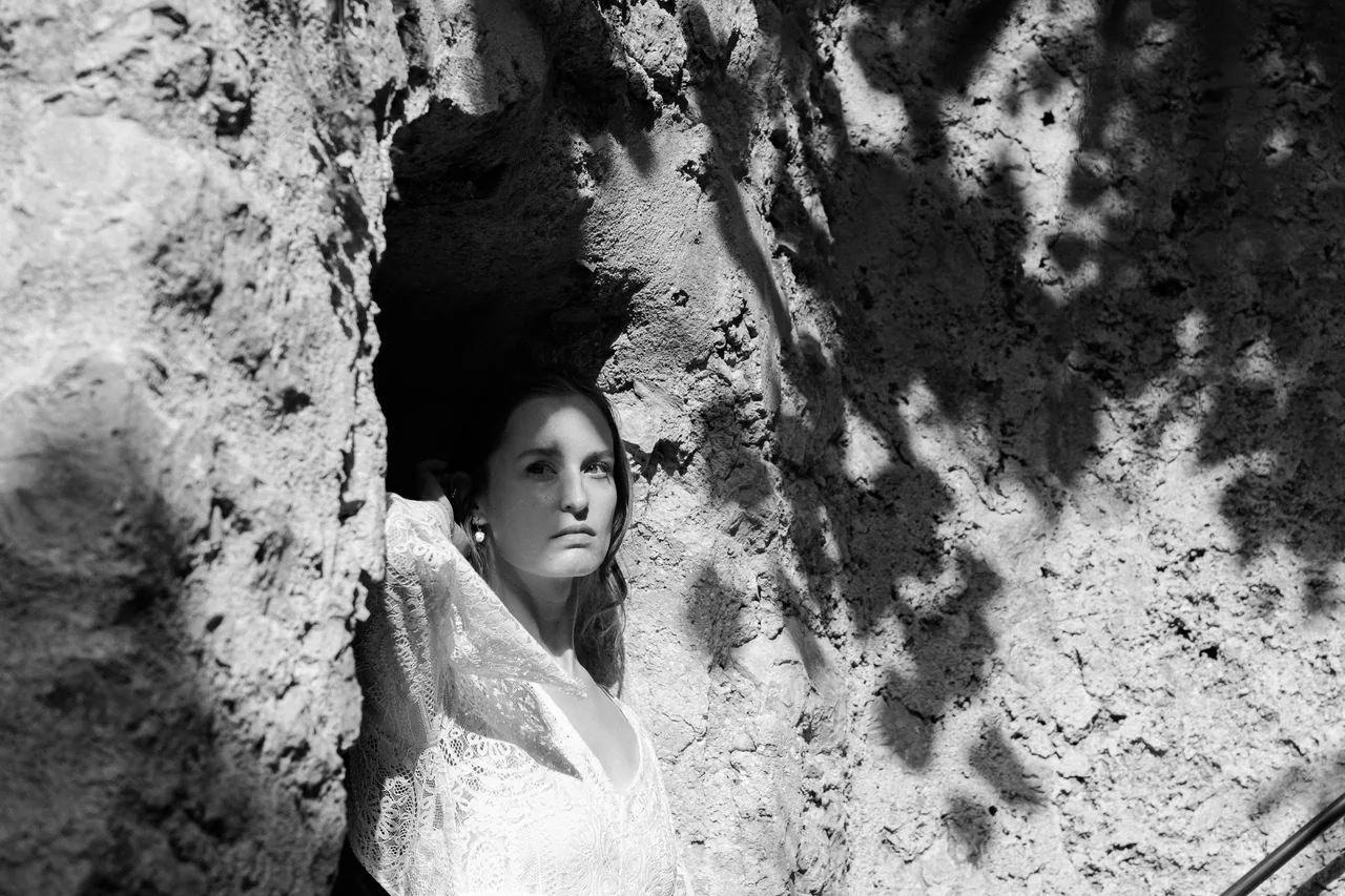 A portrait against old stone, in black and white